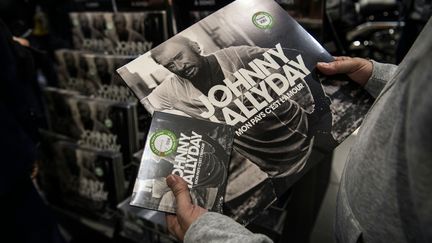 Un fan achète l'album et le vinyle du dernier disque de Johnny Hallyday,&nbsp; le 19 octobre.&nbsp; (CHRISTOPHE ARCHAMBAULT / AFP)