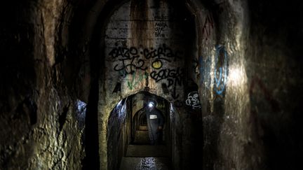 Un employé de la métropole de Lyon explore le souterrain&nbsp;qui descend du&nbsp;quartier de la Croix-Rousse jusqu'au Rhône, sur quelque deux kilomètres de galleries. (JEFF PACHOUD / AFP)