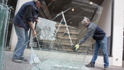 Des ouvriers remplacent la vitrine d'un concessionnaire brisée par des manifestants la veille, à Paris le 15 avril 2016. (MAXPPP)