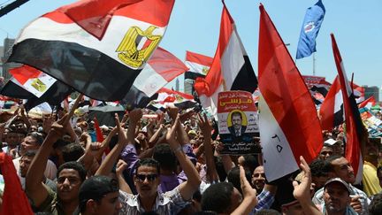 Des Egyptiens saluent le pr&eacute;sident &eacute;lu Mohammed Morsi, le 29 juin 2012 place Tahrir, au Caire (Egypte). (KHALED DESOUKI / AFP)