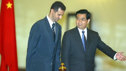 Le pr&eacute;sident chinois Hu Jintao accueille son homologue syrien Bachar Al-Assad le 22 juin 2004, lors d'une visite &agrave; P&eacute;kin (Chine). (FREDERIC J. BROWN / AFP)