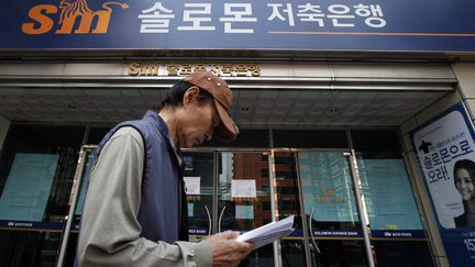 Un homme passe devant une banque Solomon Savings &agrave; S&eacute;oul (Cor&eacute;e du Sud), le 7 mai 2012. (LEE JAE WON / REUTERS)