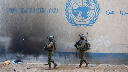 Des soldats israéliens devant le quartier général de l'agence de l'ONU pour les réfugiés palestiniens, dans la ville de Gaza, le 8 février 2024. (JACK GUEZ / AFP)