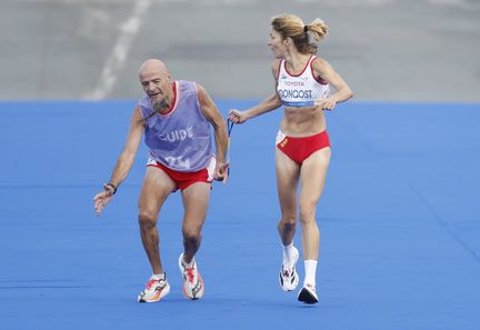 Elena Congost aide son guide dans la finale du marathon féminin des Jeux paralympiques de Paris au Stade de France à Paris, France, le 8 septembre 2024. (JAVIER ETXEZARRETA/EFE / SIPA)