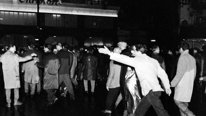 Des Algériens défilent sur les grands boulevards parisiens encadrés par les forces de l'ordre, le 17 octobre 1961. (AFP)