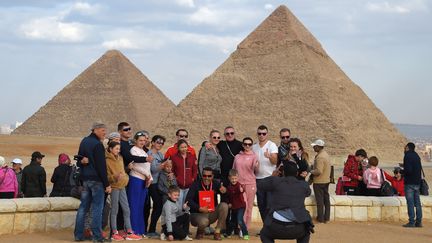 Des touristes posent devant les pyramides de Gizeh, le 29 décembre 2018.&nbsp; (MOHAMED EL-SHAHED / AFP)