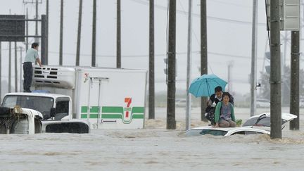 Pris au pi&egrave;ge par la brusque mont&eacute;e des eaux, des Japonais attendent l'arriv&eacute;e des secours sur le toit de leur v&eacute;hicule, jeudi 10 septembre 2015 &agrave; Joso. (KYODO NEWS / AP / SIPA)