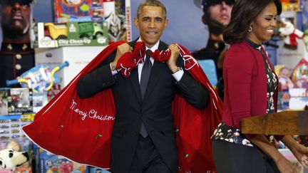 Barack Obama et son &eacute;pouse Michelle lors d'une op&eacute;ration dans un magasin de jouets de Washington (Etats-Unis), le 10 d&eacute;cembre 2014.&nbsp; (KEVIN LAMARQUE / REUTERS)