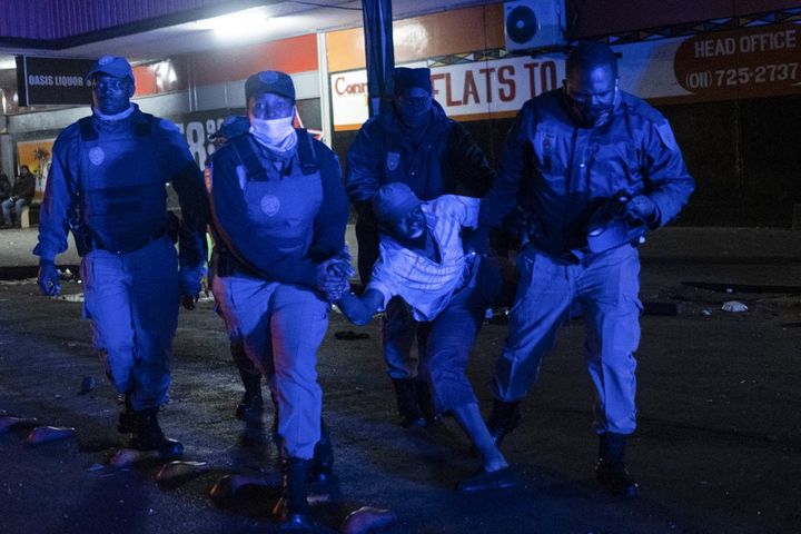 Arrestation devant un magasin d'alcools qui a été pillé dans le quartier central des affaires de Johannesburg, en Afrique du Sud, le 11 juillet 2021.&nbsp; (EMMANUEL CROSET / AFP)