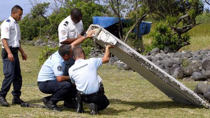 Des enqu&ecirc;teurs autour du d&eacute;bris retrouv&eacute; &agrave; Bois-Rouge, sur la commune de Saint-Andr&eacute; de La R&eacute;union, le 30 juillet 2015. (  MAXPPP)