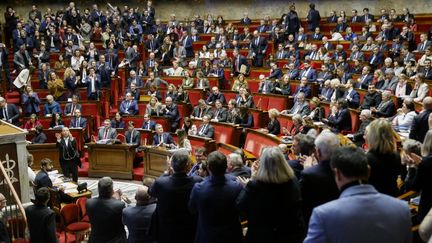 Des députés applaudissent dans l'hémicycle après l'adoption par l'Assemblée nationale d'une motion de rejet préalable du projet de loi sur l'immigration, le 11 décembre 2023. (LUDOVIC MARIN / AFP)