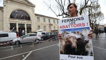 Une femme membre de l'association L214 tient une pancarte prônant la fermeture des abattoirs, le 23 mars 2017 devant le tribunal d'Alès (Gard). (SYLVAIN THOMAS / AFP)