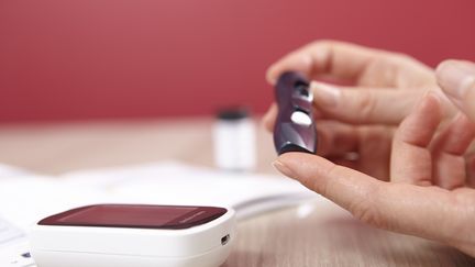 Une femme contrôle le taux de glucose dans son sang, en septembre 2015. (THEOBALD / BSIP / AFP)