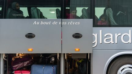 Un autocar qui transporte des migrants vers un centre d'accueil, avant son départ de Calais. "Au bout de vos rêves", le slogan de la compagnie de bus, inscrit sur la carrosserie, a été très commenté par les journalistes sur place. (SAMUEL BOIVIN / CITIZENSIDE / AFP)