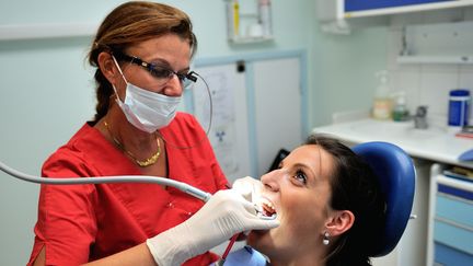 Une dentiste s'occupe d'une patiente &agrave; Bailleul (Nord), le 6 septembre 2013. (PHILIPPE HUGUEN / AFP)