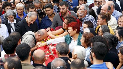 Des proches des victimes de l'attentat d'Ankara (Turquie) se recueillent sur le cercueil de l'une d'entre elles, le 11 octobre 2015. (UMIT BEKTAS / REUTERS)