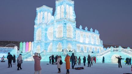 Tourists walk past a replica of Notre-Dame de Paris at the ice sculpture festival in Harbin, China, December 18, 2023. (XIE JIANFEI/XINHUA)