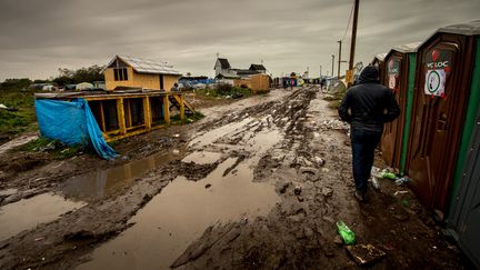 Un migrant marche dans une allée de la "jungle" de Calais, le 21 octobre 2015. (PHILIPPE HUGUEN / AFP)