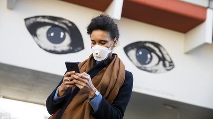 Une femme consulte son smartphone, le 1er avril 2020, à Berlin (Allemagne). (EMMANUELE CONTINI / NURPHOTO / AFP)