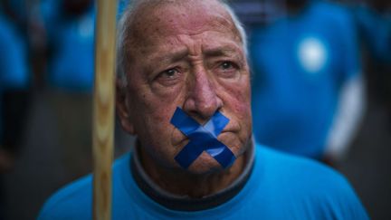 Un retrait&eacute; de la soci&eacute;t&eacute; Telefonica manifeste contre le plan de licenciement qui touche les employ&eacute;s de la soci&eacute;t&eacute; &agrave; Barcelone (Espagne), le 17 d&eacute;cembre 2013. (EMILIO MORENATTI / AP / SIPA)