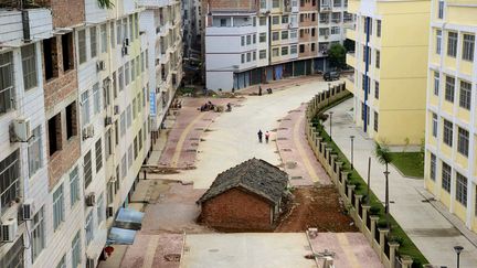 Les propri&eacute;taires de cette "maison clou" de Nanning, ville du sud de la Chine, refusent sa destruction et bloquent l'ach&egrave;vement de la route.&nbsp; (REUTERS)