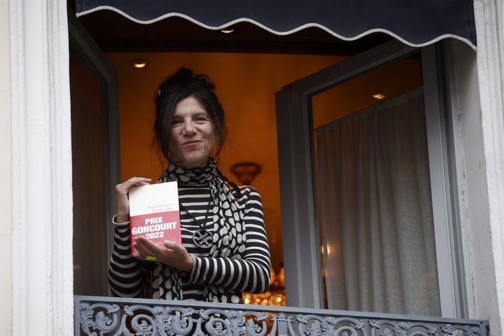 Brigitte Giraud tient son roman "Vivre Vite" (Flammarion) à la fenêtre du restaurant Drouant après avoir reçu le prestigieux prix Goncourt, à Paris, le 3 novembre 2022. (YOAN VALAT / EPA / MAXPPP)