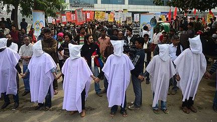 Des militants bangladais habillés de linceuls, lors d'une manifestation devant les bureaux de l’Association des fabricants et exportateurs de textile du Bangladesh à Dhaka, le 28 janvier 2013.  (AFP PHOTO \/ Munir uz ZAMAN)