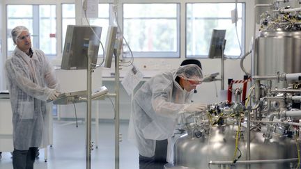 Deux techniciens travaillent sur une ligne de production à l'usine Sanofi de Neuville-sur-Saône (Auvergne-Rhône-Alpes) (PHILIPPE DESMAZES / AFP)