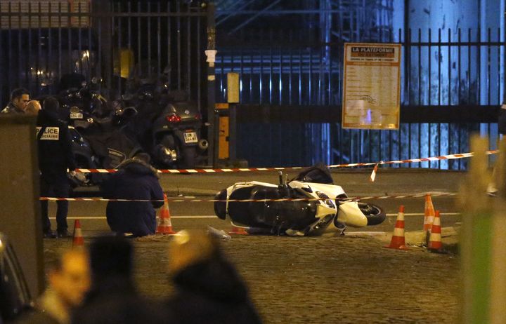 Des enqu&ecirc;teurs autour du scooter des braqueurs abandonn&eacute;s dans le 15e arrondissement de Paris, &agrave; proximit&eacute; d'un salon de coiffure, apr&egrave;s le braquage de la bijouterie Cartier.&nbsp; (KENZO TRIBOUILLARD / AFP)