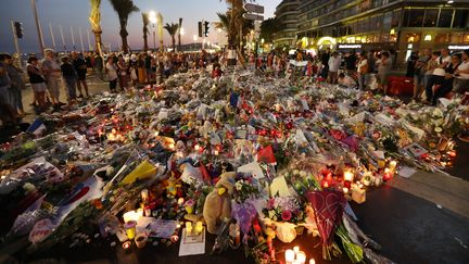 Des personnes rendent hommage aux victimes de l'attentat de Nice, le 18 juillet 2016, sur la promenade des Anglais à Nice (Alpes-Maritimes). (VALERY HACHE / AFP)