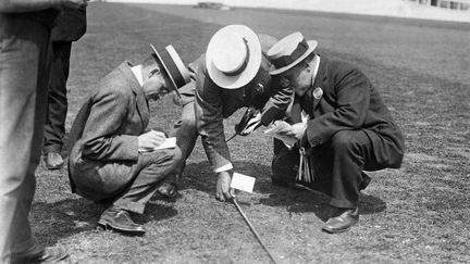 Des juges arbitres mesurent un lancer de javelot. (HULTON ARCHIVE / GETTY IMAGES)