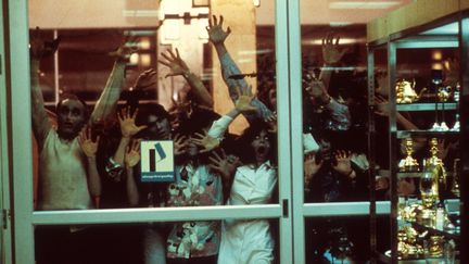 Des zombies se pressent contre la porte&nbsp;du centre commercial de "Zombie", de George A. Romero, critique féroce de la société de consommation sortie en 1978. (ARCHIVES DU 7EME ART / PHOTO 12 / AFP)