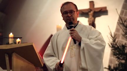 Le prêtre Nicolas Guillou avec un sabre Star Wars lors de la messe de Noël, à Saint-Erblon (Ille-et-Vilaine), le 24&nbsp;décembre&nbsp;2015. (NICOLAS GUILLOU)