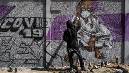 Au Sénégal, les artistes se mobilisent pour diffuser des messages de prévention auprès des jeunes. Madzoo et ses coéquipiers graffeurs du collectif RBS Crew ont décidé de tagger les murs dans le quartier populaire de Parcelles Assainies, à Dakar, pour inciter les jeunes à prendre au sérieux le virus et à respecter les recommandations sanitaires.&nbsp; (SYLVAIN CHERKAOUI / SIPA/ AP PHOTO)