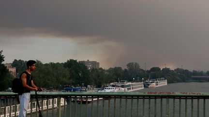 La ville d'Avignon sous un nuage de fumée noire alors qu'un incendie est en cours dans le massif de la Montagnette, le 14 juillet 2022. (REY J?R?ME / MAXPPP)