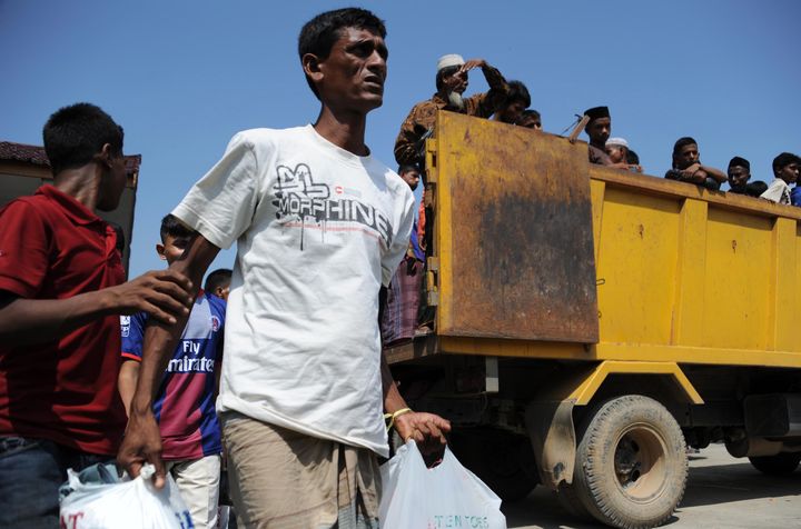 Des migrants secourus en pleine mer arrivent dans le port de&nbsp;Kuala Cangkoi, dans la province d'Aceh (Indon&eacute;sie), le 13 mai 2015. (CHAIDEER MAHYUDDIN / AFP)