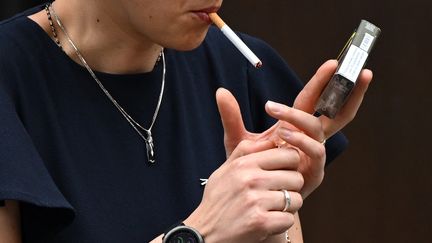 Une femme fume une cigarette à Londres (Royaume-Uni), le 9 juin 2022. (JUSTIN TALLIS / AFP)