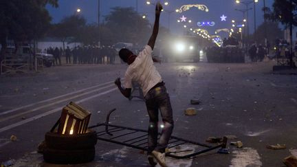 Un manifestant jette des pierres sur des policiers lors d'affrontements &agrave; Dakar (S&eacute;n&eacute;gal), le 31 janvier 2012. (JOE PENNEY / REUTERS)