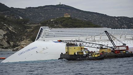 Des techniciens installent des valves sur des trous sur 6 des 23 r&eacute;servoirs, le 27 janvier 2012, pour permettre le pompage du carburant contenu dans le Concordia. (FILIPPO MONTEFORTE / AFP PHOTO)