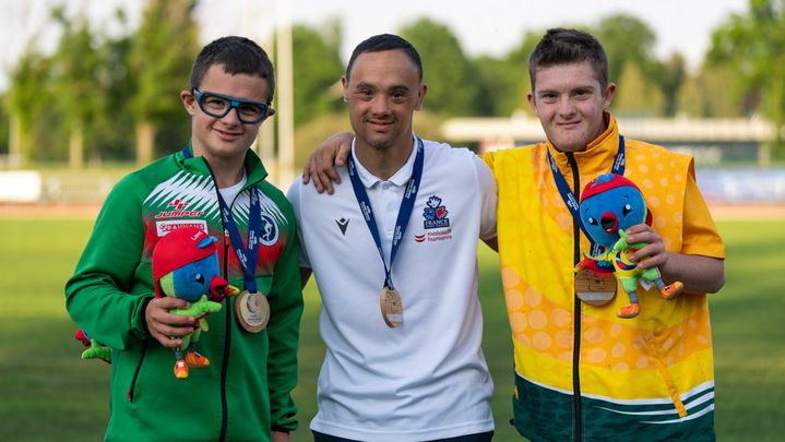 Le Français Nicolas Virapin (au centre) pose, sa médaille d'or autour du cou, avec ses concurrents bulgare et australien du triathlon classe II2 lors des Global Games, le 6 juin 2023. (YONATHAN KELLERMAN)