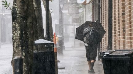 Une passante sous les fortes pluies qui ont frappé la Nouvelle-Orléans dimanche 29 août, avant l'arrivée de l'ouragan Ida en Louisiane. (BRANDON BELL / GETTY IMAGES NORTH AMERICA / AFP)