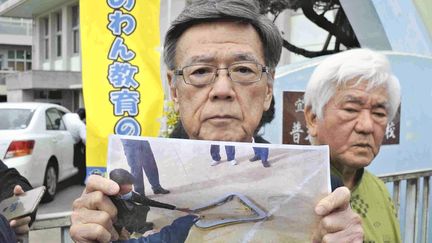 Le gouverneur de la préfecture d'Okinawa, Takeshi Onaga, s'adresse aux médias avec la photographie d'une&nbsp;fenêtre d'hélicoptère américain qui a chuté près d'une école élémentaire, mercredi 13 décembre 2017. (HIROTAKA KURIYAMA / YOMIURI / AFP)