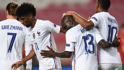 L'équipe de France félicite Ngolo Kanté (n°13), auteur du but vainqueur contre le Portugal, samedi 14 novembre. (PATRICIA DE MELO MOREIRA / AFP)