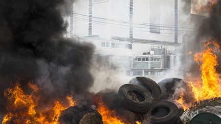 Des pneus br&ucirc;lent &agrave; Crehen (C&ocirc;tes d'Armor), dans une manifestion des &eacute;leveurs contre une coop&eacute;rative laiti&egrave;re, le 24 juillet 2015. (EMMANUELLE RODRIGUE / CITIZENSIDE.COM / AFP)