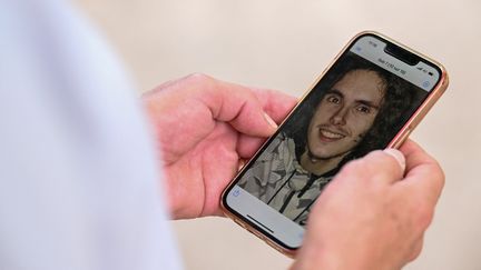 Paul Raoult montre la photo de son fils, Sébastien Raoult,&nbsp;étudiant français détenu au Maroc et soupçonné de cybercriminalité par les Etats-Unis, le 1er août 2022 à Epinal (Vosges).&nbsp; (JEAN-CHRISTOPHE VERHAEGEN / AFP)