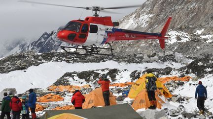 Un h&eacute;licopt&egrave;re se pose au camp de base de l'Everest, touch&eacute; par des avalanche, pour secourir les bless&eacute;s, dimanche 26 avril 2015.&nbsp; (ROBERTO SCHMIDT / AFP)