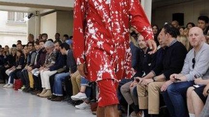 Chez le Japonais Issey Miyake, un nouveau créateur pour la ligne masculine Yusuke Takahashi, 28 ans, présentait sa première collection. "Open the window and look at the world" serait le slogan maison cette saison... en effet, juste avant le top départ du défilé, trois mannequins ont ouvert les fenêtres de la véranda... Le créateur a particulièrement travaillé les techniques traditionnelles de teinture en tye and dye, avec une grande variété de couleurs. J'ai adoré la grande chemise rouge tachetée de blanc, qui se décline aussi en bleu et en gris. A piquer immédiatement à ces Messieurs. Les couleurs semblent être mélangées de façon anarchique sur certaines pièces alors que l'allure est très géométrique sur d'autres. Ainsi sur une grande blouse noire portée sur un bermuda apparaissent des carrés rouges, blancs et bleus.
 (F.Guillot/AFP)