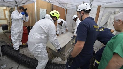 Des enquêteurs et des pompiers ouvrent une tombe dans un cimetière allemand de la Cité du Vatican, le 11 juillet 2019. (VATICAN MEDIA / AFP)