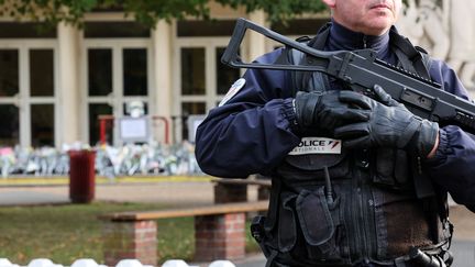 Un policier français monte la garde devant le lycée Gambetta à Arras où un professeur a été tué, le 16 octobre 2023. (DENIS CHARLET / AFP)