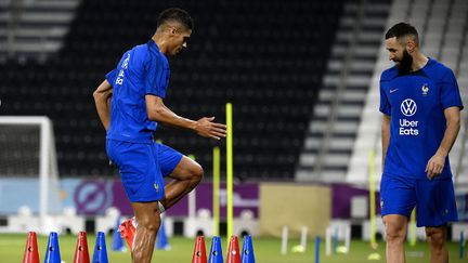 Raphaël Varane et Karim Benzema ont participé à un entraînement physique spécifique lors de la séance collective de l'équipe de France au stade Jassim bin Hamad de Doha, le 17 novembre 2022. (FRANCK FIFE / AFP)